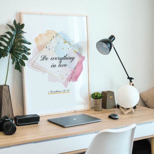 Do Everything in Love Wall Art in a black frame on the desk