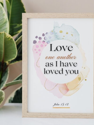 Love One Another Wall Art on the white table, palm next to it