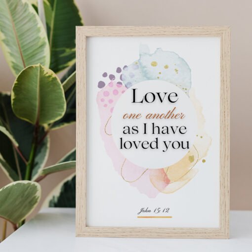 Love One Another Wall Art on the white table, palm next to it