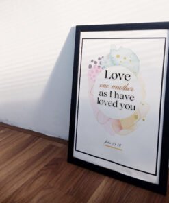 side view of Love One Another Wall Art leaning on a white wall