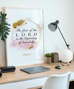 Proverbs 17 Biblical Wall Art placed on a wooden desk naxt to a black lamp