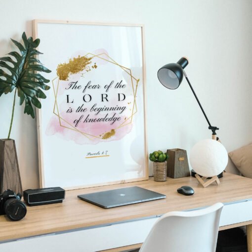 Proverbs 17 Biblical Wall Art placed on a wooden desk naxt to a black lamp