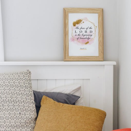 Proverbs 17 Biblical Wall Art hung in a bedroom above a white bed with three pillows