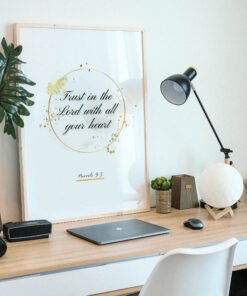Trust in the Lord Wall Art framed in beige placed on a wooden desk, a plant next to it