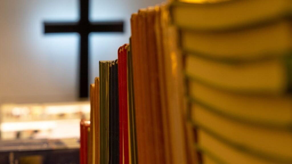 Chistian bookstore with piles of books and a wooden cross in the background